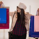 young girl holding packages looking at them.