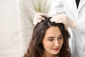 Woman with hair loss problem receiving injection in clinic